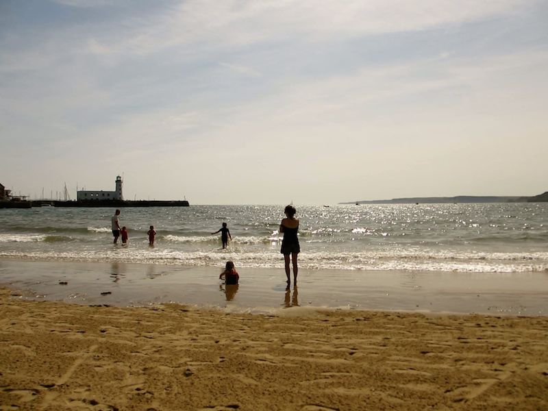People on a beach - Nine UK beaches you can reach car-free.
